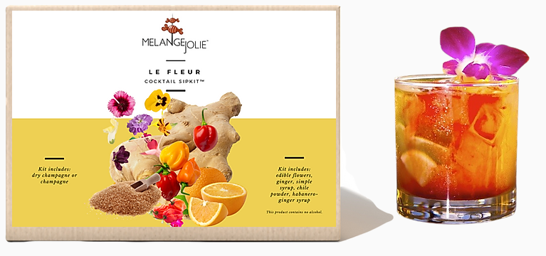 Mélange Jolie Le Fleur Cocktail SipKit™ featuring a glass, bar spoon, cocktail sticks, and various ingredients including edible flowers and syrups.